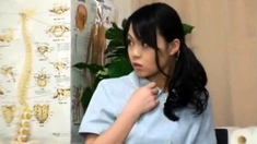 An Asian teen in a schoolgirls uniform is sitting on the
