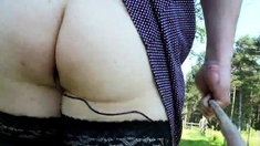 Crossdresser walking with butt plug in the forest